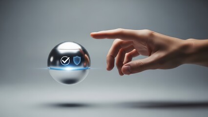Sleek, futuristic metallic sphere displaying glowing blue security icons—a checkmark and shield—is delicately touched by a human hand with soft skin tones, illuminated by a subtle studio light against