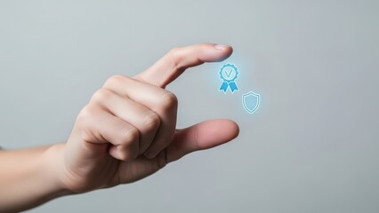 A fair-skinned human hand with neatly trimmed fingernails delicately pinches and holds two glowing, translucent digital icons – a blue ribbon with a checkmark and a shield outline – seemingly