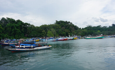 Colorful Fishing Boats Anchored in Calm Waters at Sendang Biru Beach, South Malang, East Java, Indonesia