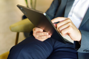 Person using tablet while sitting in chair indoors © muse studio