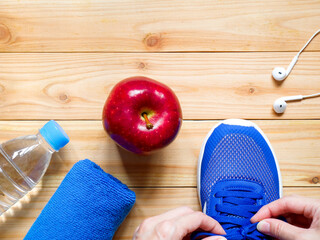 Hands tying shoelaces. Exercise and fitness equipment.