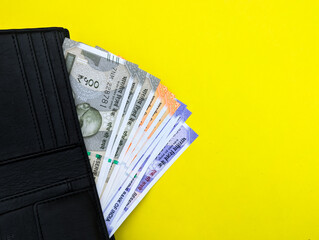 indian currency bank note inside wallet isolated on yellow transparent background