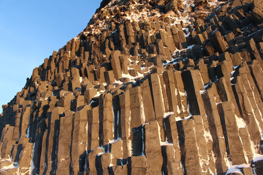Basalt column formations with snow at Icelandic Black Sand Beach