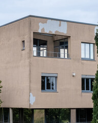 Building with partially peeled paint and modern architecture in a cloudy sky during daytime