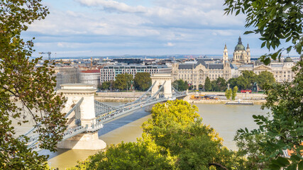 Budapest city framed by trees over Danube river - Hungary