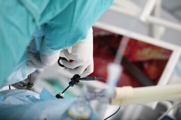 Laparoscopic surgery. Minimally invasive surgery. Laparoscopic instruments in hands of surgeon. Operations on internal organs. Modern surgical method.