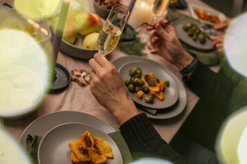 Christmas family dinner with candles, festive food and cozy warm New Year atmosphere at the table