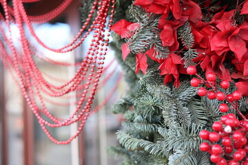 Christmas tree decorated with red flowers and berries on a background of red beads