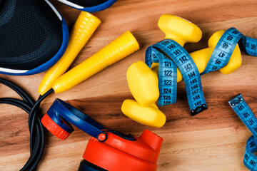 Sports equipment on a wooden table, weight loss and physical activity concept.