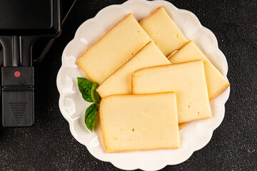 Raclette cheese portion slicing natural product tasty snack fresh delicious gourmet food background on the table rustic top view copy space