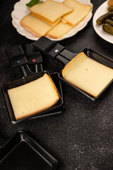 Raclette cheese portion slicing natural product tasty snack fresh delicious gourmet food background on the table rustic top view copy space