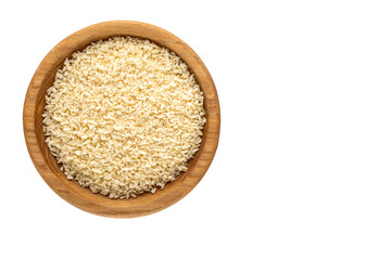 Coconut shavings in a wooden saucer on a white background, top view, close-up.