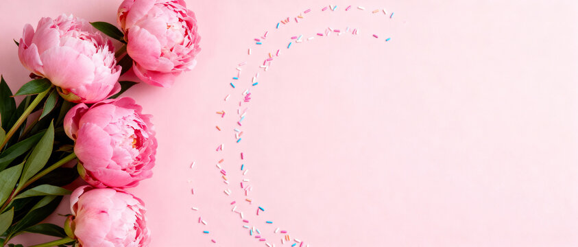 Pink peonies arranged on pastel background with colorful confetti creating a festive curved design, minimalist floral composition - Powered by Adobe