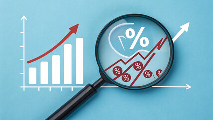 Business growth analysis with magnifying glass on financial charts and percentage signs.