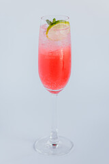 Refreshing Pink Sparkling Beverage with Mint and Lime Slice in Elegant Glassware on Light Gray Background