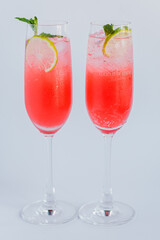 Refreshing Pink Cocktail with Citrus Garnish and Mint in Elegant Flute Glasses