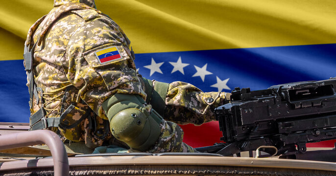 Venezuela flag with soldier at machine gun turret in front of it. Closeup side view.