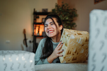Young woman smiling, holding christmas gift present