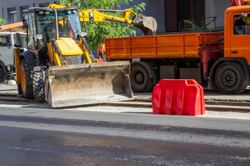 Road construction equipment on the road. A bulldozer, a dump truck, and an excavator.