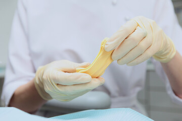 The doctor holds in his hands a mass for making dental casts. Material for making dental casts. A mass for dental casts in dentistry.