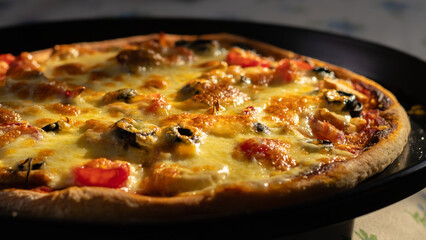 Delicious pizza freshly baked with melted mozzarella cheese and veggie toppings close-up.