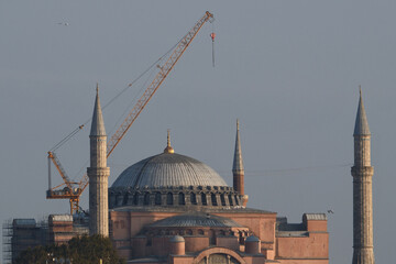 Obraz premium Construction Crane Towering Over Historic Hagia Sophia Mosque in Istanbul. Tower Crane at Hagia Sophia During Restoration, Istanbul, Turkey