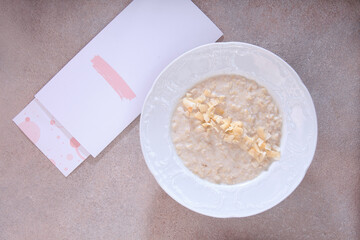 Oatmeal porridge and a poached egg on a white plate. The concept of healthy eating. Cafe menu. Flat lay. Top view. Copy space.