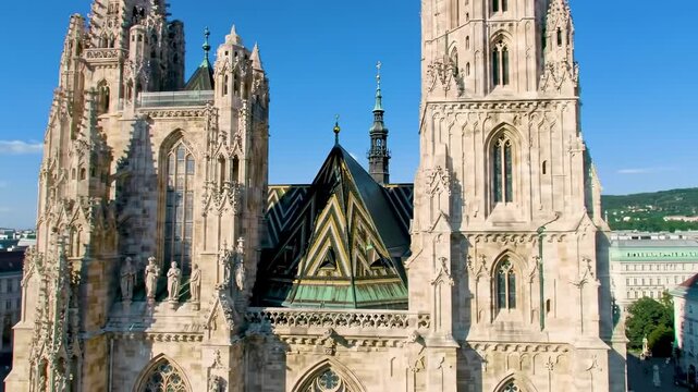 Detailed view of a beige ornate gothic cathedral featuring towers and a zigzag patterned roof under a bright blue sky