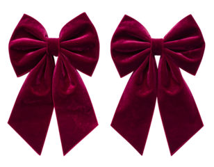 Two close-up, plush, burgundy velvet bows isolated against a black background