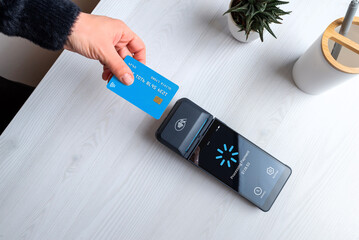Contactless card payment processing on POS terminal with loading screen, representing digital transaction, payment verification, and modern fintech workflow