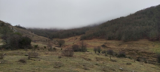 Paisaje de valle montañoso bajo un denso manto de niebla y nubes bajas en un día de invierno en Palencia, España