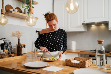 Woman preparing healthy avocado meal in kitchen