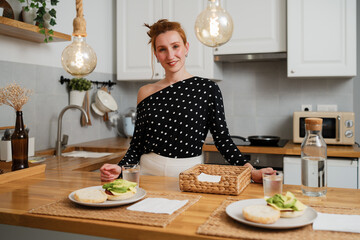 Woman smiling in cozy kitchen preparing breakfast