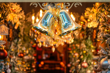 A pair of golden bells tied with bows adorn the decorations in a festive Christmas atmosphere at night