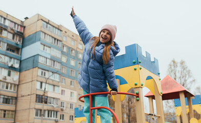 A happy teenage girl runs through a maze on a street playground, winning and coming out on top. Photo, childhood concept.