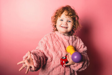 Child playing with toys in a colorful setting while showing a playful expression with enthusiasm and energy