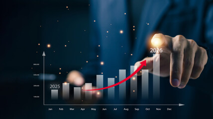 A business professional points at an upward financial chart from 2025 to 2026, representing business growth, revenue increase, financial forecasting, performance analysis, and strategic planning.