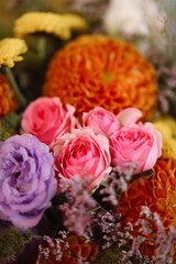 Pink peony bridal bouquet tied with white ribbon placed on neutral surface near light wall. Elegant floral arrangement, wedding flowers, romance, beauty concepts.