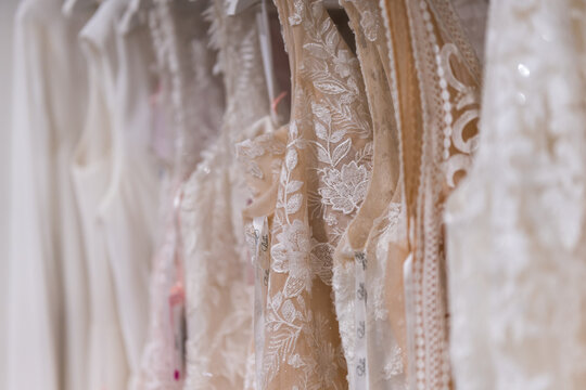 Elegant bridal gowns hanging in a fashion store showing detailed wedding dress design and refined bridal couture close up