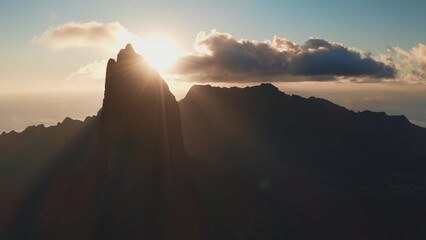 Moorea island majestic mountain peaks emerging from the dark silhouette as golden sunbeams radiate across the sky, highlighting the tranquil tropical landscape and inspiring a sense of calm © Goinyk