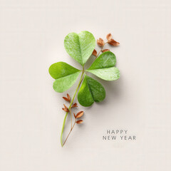 Four-leaf clover minimalist design with dried flowers for new year wishes