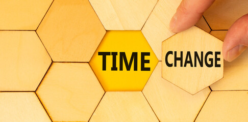 Time change symbol. Concept word Time change on beautiful wooden puzzles. Businessman's hand. Beautiful yellow paper background. Business time change concept. Copy space.