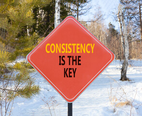 Consistency is the key symbol. Concept words Consistency is the key on beautiful red road sign. Beautiful winter forest background. Business consistency is the key concept. Copy space.