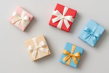 Flat lay of pastel and bright colored gift boxes with satin bows on a light gray background, ideal for celebration or birthdays..