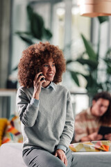 Happy woman talking on phone in modern office