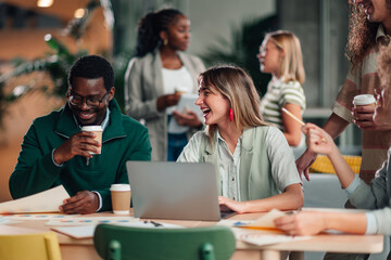 Diverse business people collaborating and laughing in office