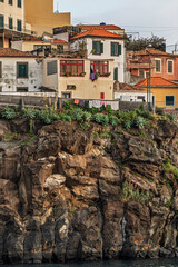 Coastal houses on a cliffside in the village of Camara de Lobos, Madeira, Portugal