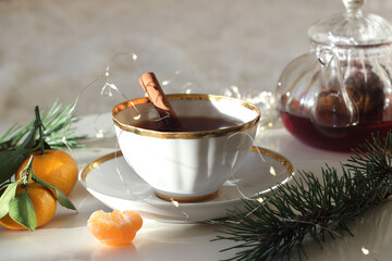Black tea in a cup on a white table. New Year's decor.
