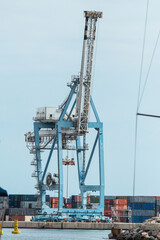 Obraz premium A big blue crane on the dock with a man inside.