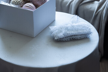 Christmas ornaments and decorative elements on round table in soft daylight